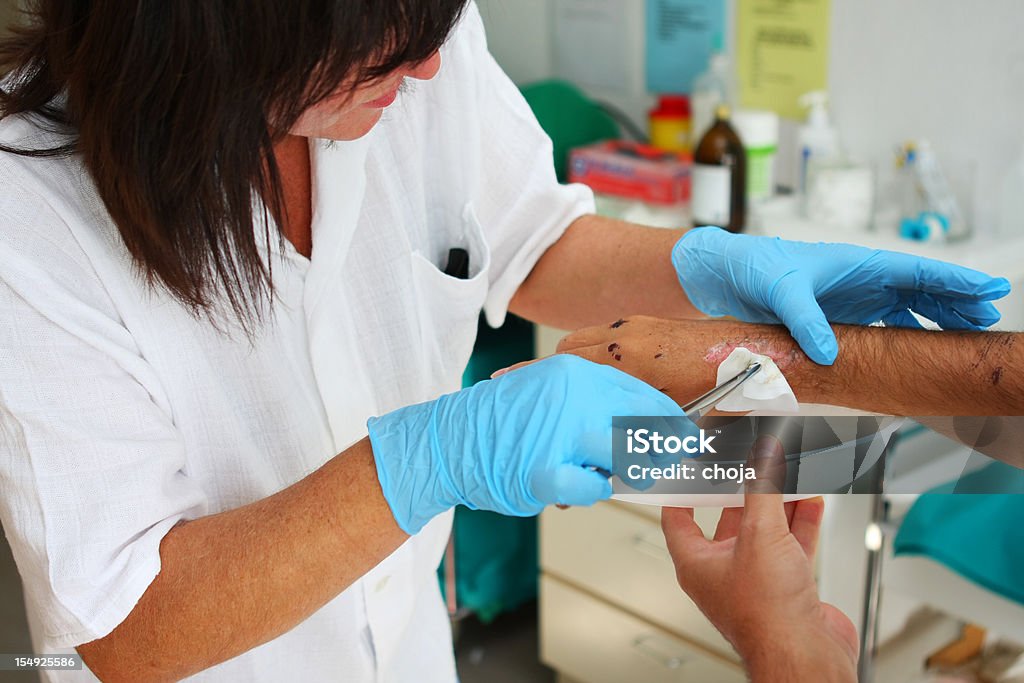 Enfermeira no work.taking cuidar de feridos paciente - Foto de stock de Antisséptico royalty-free