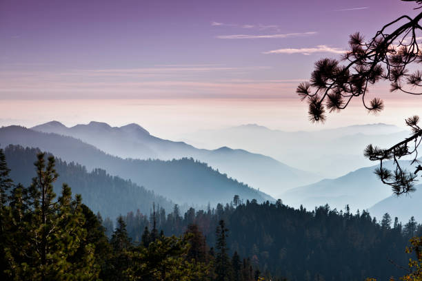 A truly iconic sunset overlooking a breathtaking view in Southern California's Sequoia National Park. The sky is glowing with a rich and vibrant red to orange to blue gradient light and the various mountain ranges disappear into the haze in the distance. No clouds. No people. No distractions.