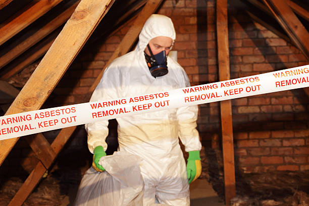 man removing asbestos A worker wearing protective clothing while clearing the hazardous substance,asbestos,from an old attic. absence stock pictures, royalty-free photos & images