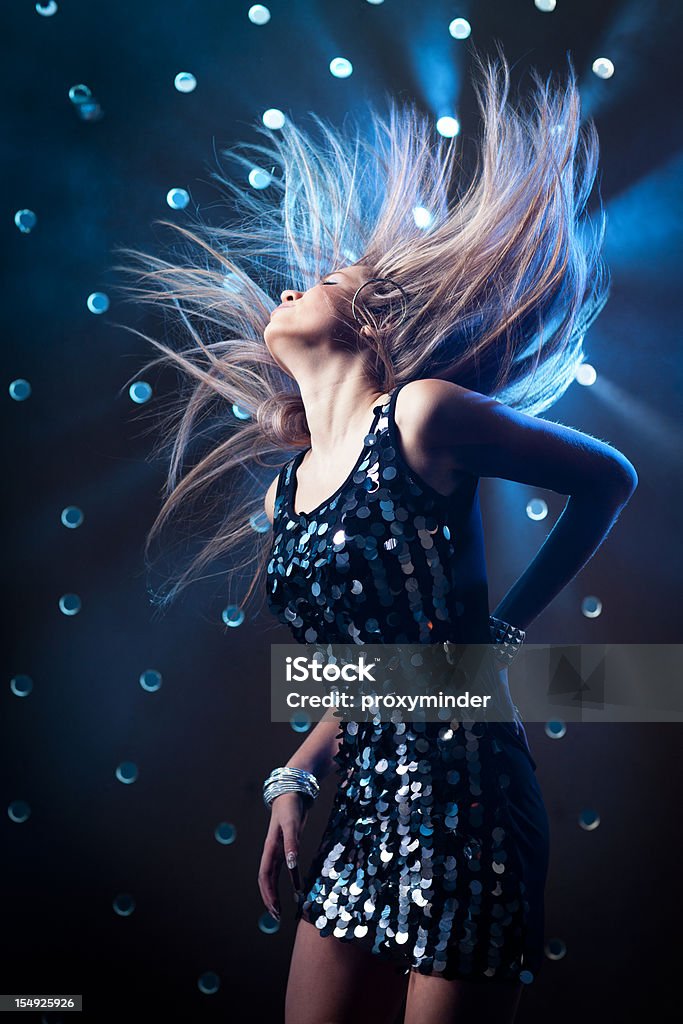 Giovane donna ballando in discoteca sfondo fumé - Foto stock royalty-free di Locale notturno