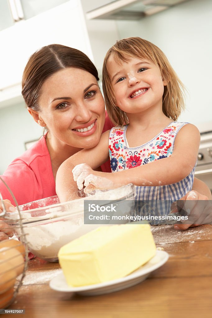 Chica joven ayudando a madre para hornearla tortas en la cocina - Foto de stock de 2-3 años libre de derechos