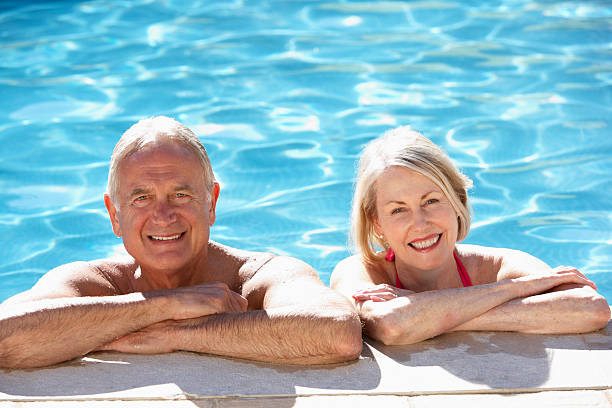 istock Senior Couple Relaxing In Swimming Pool 154927018