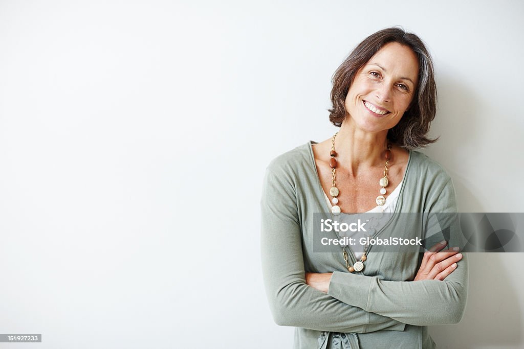 歳の女性は上品な中に彼女の腕を組むアゲインストホワイト - 女性のロイヤリティフリーストックフォト