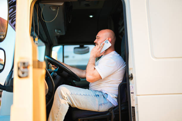 motorista sentado no banco do caminhão branco falando ao telefone - semi truck driver pride white - fotografias e filmes do acervo