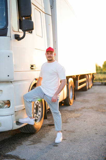 homem de chapéu vermelho parado por caminhão branco - semi truck driver pride white - fotografias e filmes do acervo