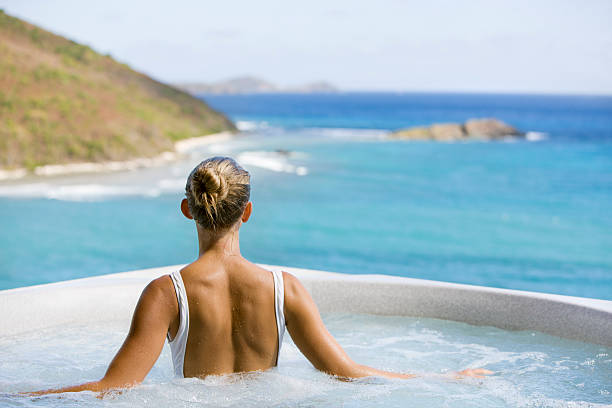 unrecognizable woman soaking in a hot tub whirlpool stock photo