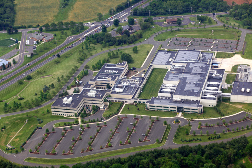 Aerial view of a large office park complex and parking lot.  Shot from the window of an airship.