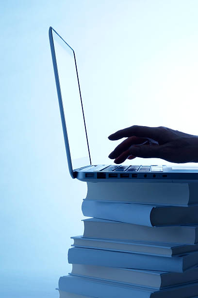istock Blue tinted image of typing keyboard on blank books 154930251