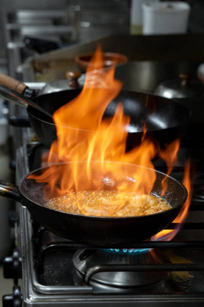 istock Pan on fire while flambeeing prawns for a delectable meal in a commercial kitchen, big skillet in flames 1549308205