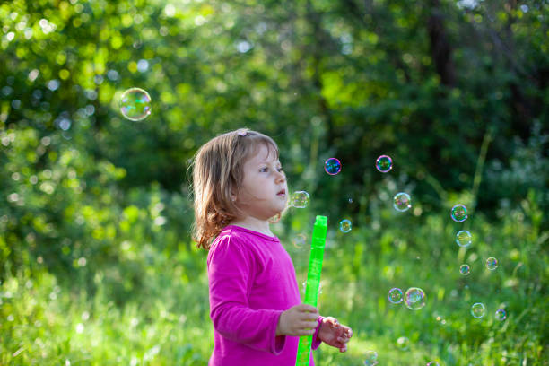 Little girl blowing soap bubbles
