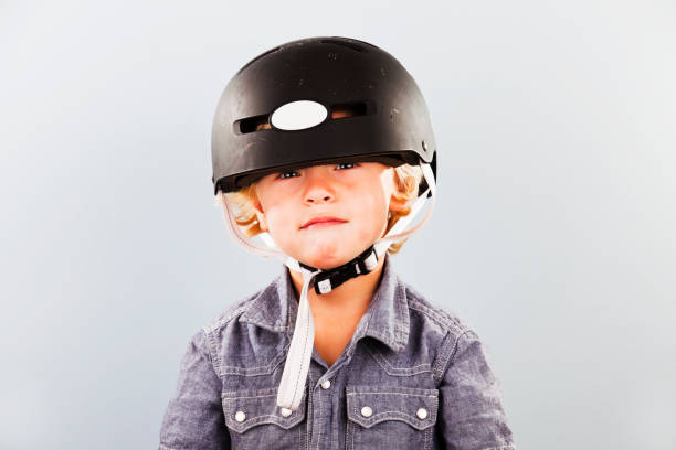 African American child boy in engineering holding construction blueprint and wearing yellow safety helmet outdoor in the park. Education concept