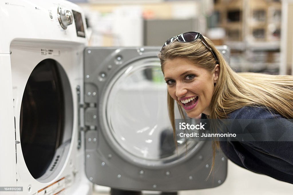 Młoda kobieta zakupy dla pralki - Zbiór zdjęć royalty-free (Kupować)