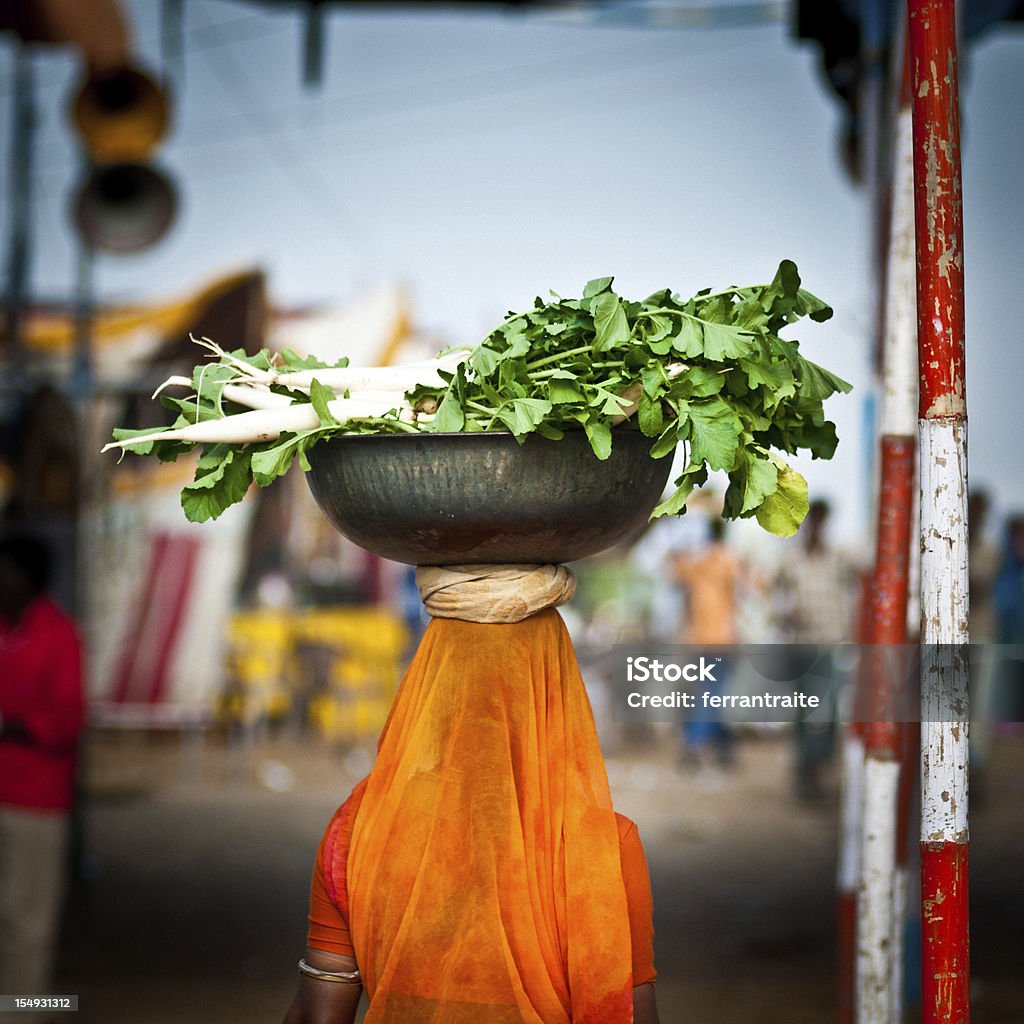 Donna portare carote sulla sua testa di Pushkar - Foto stock royalty-free di Cibo di strada