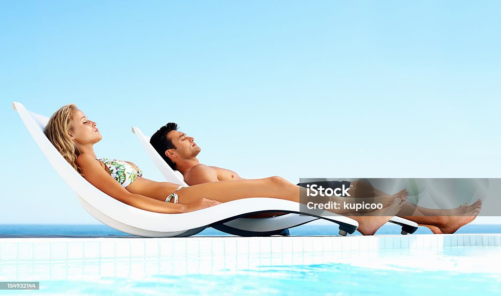 リラックスしたカップルスイミングプールで日光浴をする - プールのロイヤリティフリーストックフォト