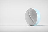 Close-up shot of a round pill on white background