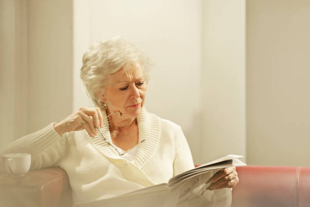 istock senior woman reading newspaper 154932339