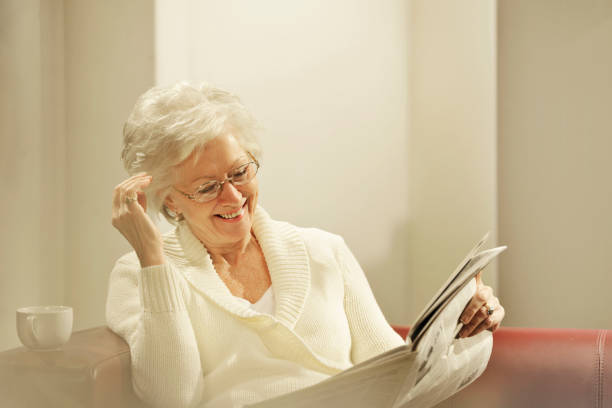 istock senior woman reading newspaper 154932340