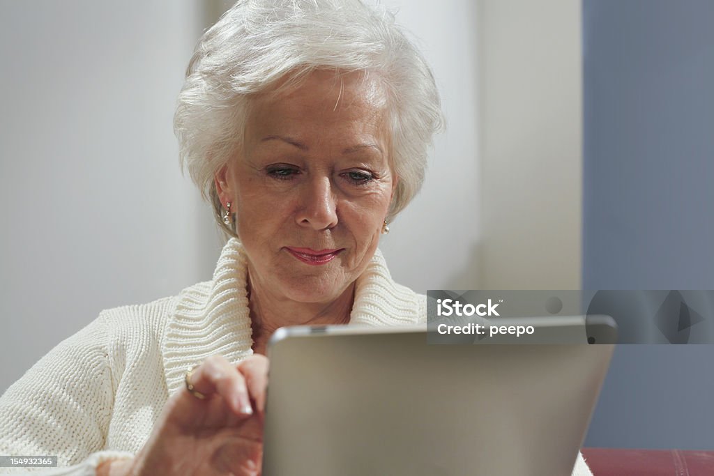 Mujer senior usando tableta - Foto de stock de Adulto libre de derechos