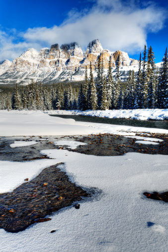 Castle Mountain stands behind the shores of the Bow River in Banff National Park, Alberta, Canada