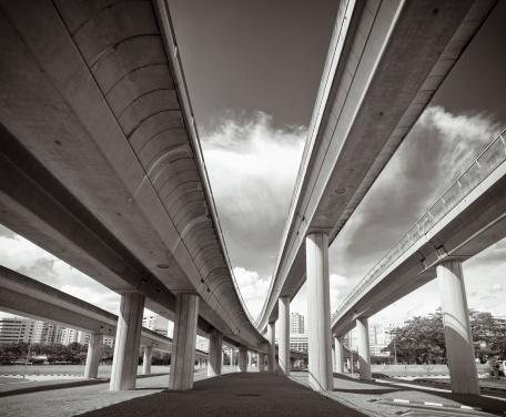 The view from underneath converging concrete transportation structures in Singapore City.