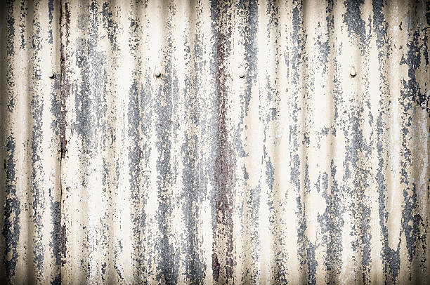 Damaged Corrugated Metal Surface Background Full frame close-up of the rusty and worn metal exterior of an old building. galvanized stock pictures, royalty-free photos & images