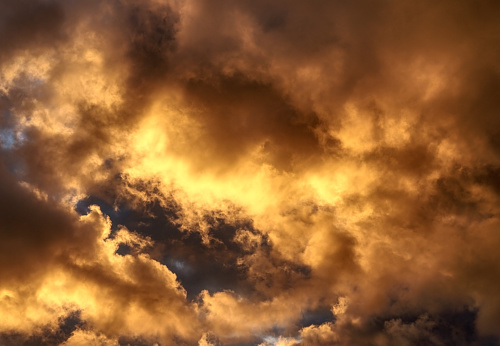 Unusual dramatic sky with fantastic golden clouds and sun. Abstract natural background in warm yellow and orange sunset colors 3D illustration.