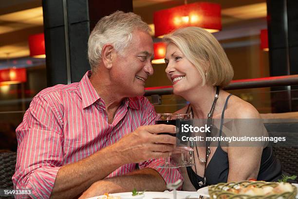 Senior Par Disfrutar De Comida En El Restaurante Foto de stock y más banco de imágenes de Restaurante - Restaurante, Pareja mayor, Sentarse a comer