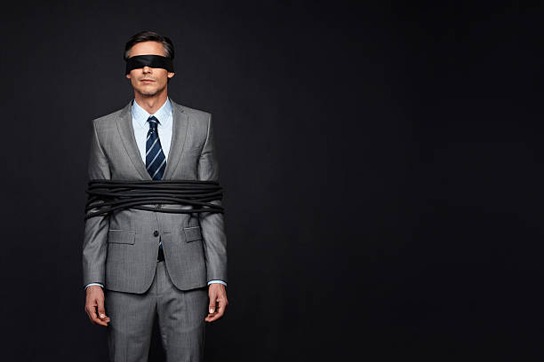 Controlled by the business world Man wearing blindfold while tied up hostage photos stock pictures, royalty-free photos & images