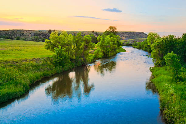peaceful sunset stream in rural Montana this file must be re-assigned to the proPhoto color profile and then viewed in that profile. stream body of water stock pictures, royalty-free photos & images
