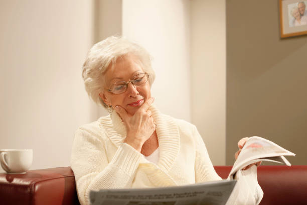 istock senior woman reading newspaper 154934357
