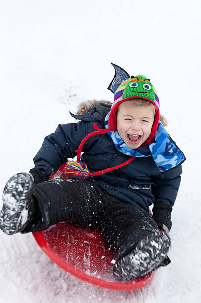 caucasiano feliz menino deslizando no inverno - golf child sport humor imagens e fotografias de stock
