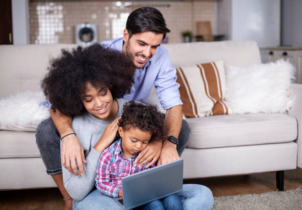 Happy family with little kids enjoying using laptop computer together stock photo