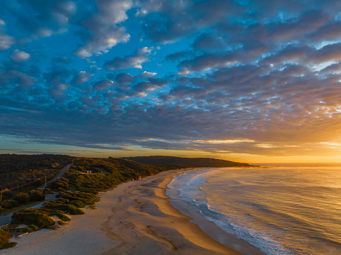Sunrise seascape with cloud filled sky at Catherine Hill Bay on the Central Coast of NSW, Australia.
