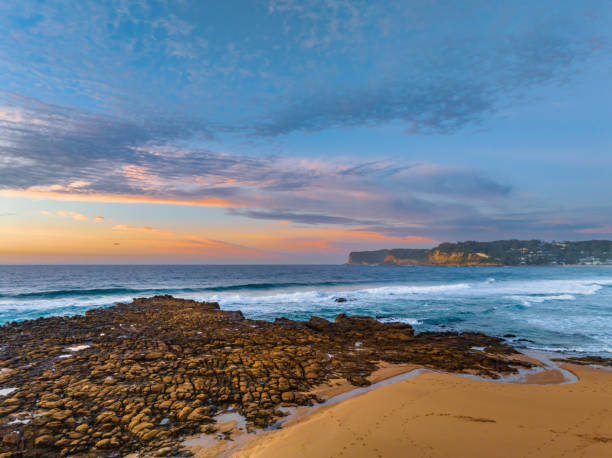 istock Ocean sunrise with rock platform and clouds 1549375376