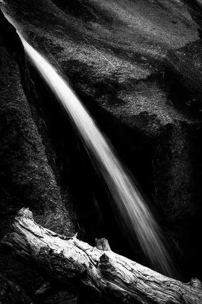 Black and white of a mountain stream flowing in between rocks