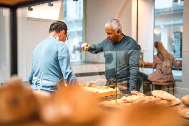 istock Mature Hispanic Male Selecting Fresh Bread At An Artisan Bakery 1549437235