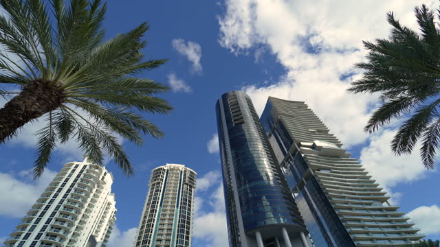 Low angle view of Sunny Isles Beach city with expensive highrise hotels and condo buildings on Atlantic ocean shore. American tourism infrastructure in coastal southern Florida