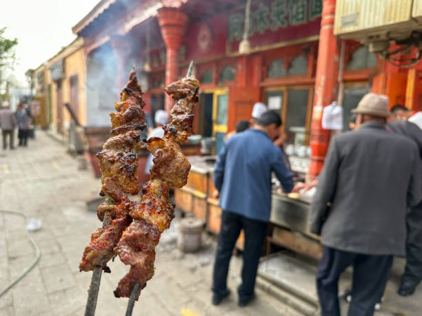 Kuqa，XINJIANG / China -April 21，2023:The commercial street in the old city of Kuqa, Xinjiang,People eat local food in restaurant’s