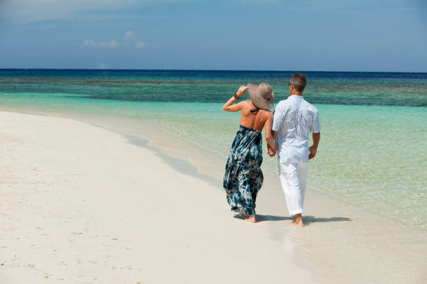 istock Couple walking along tropical beach 154945829