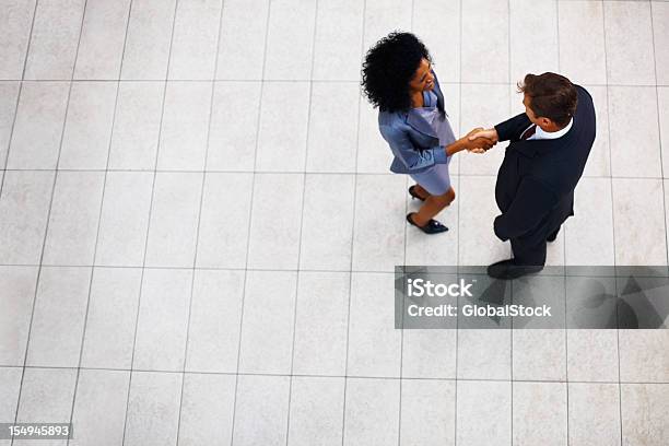 Businesswoman Greeting Male Partner Stock Photo - Download Image Now - Handshake, Directly Above, Business