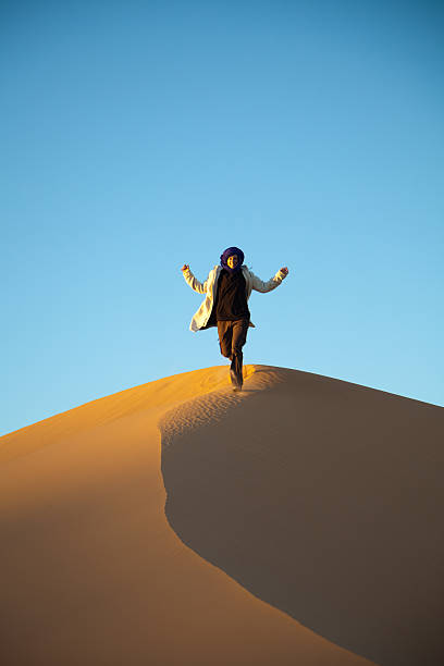 istock Woman running down a dune in Libyan Sahara desert 154945957