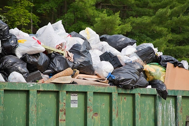 heap of trash bags an rural use garbage dumpster is overwhelmed by the holiday weekend at the lake overflowing dumpster stock pictures, royalty-free photos & images