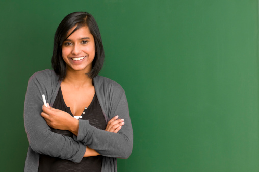 smiling student / teacher standing at blackboard - add your text