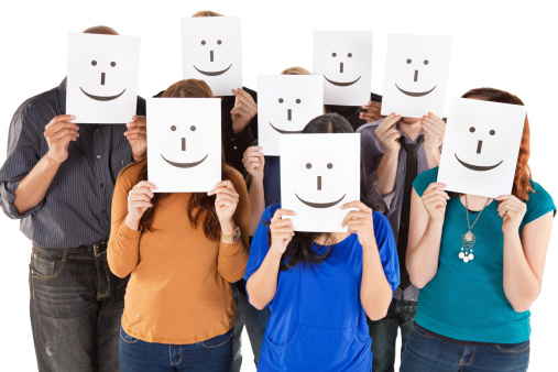 Group of People All Holding Smiley Faces. Isolated on White.