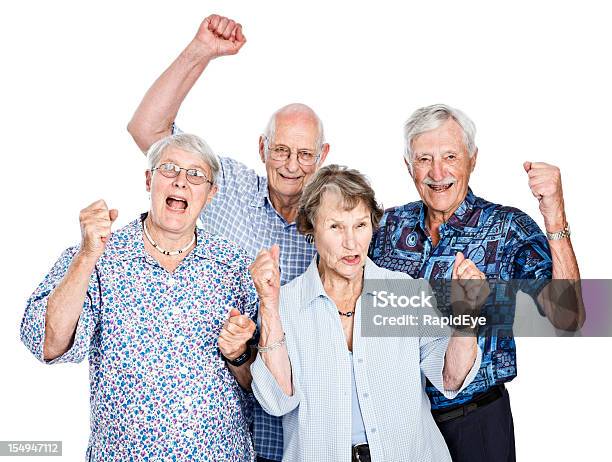 Four Happy Seniors Cheering And Waving Clenched Fists Stock Photo - Download Image Now