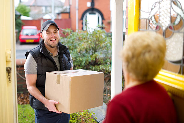 istock Smiling delivery man gives gran her parcel 154947184