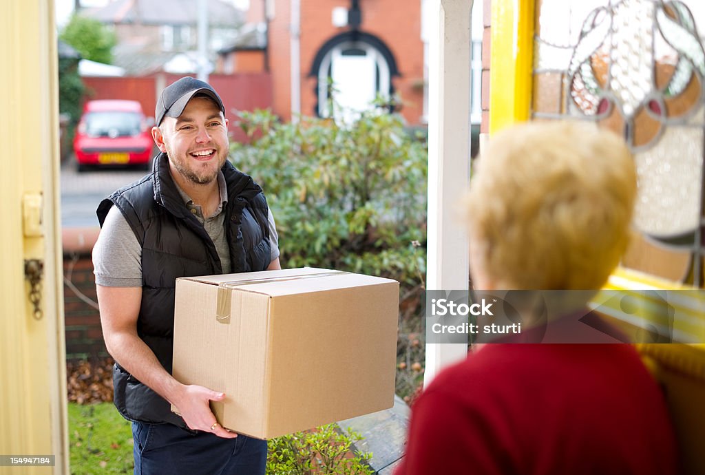 Улыбающаяся доставка человек дает gran ее parcel - Стоковые фото 70-79 лет роялти-фри