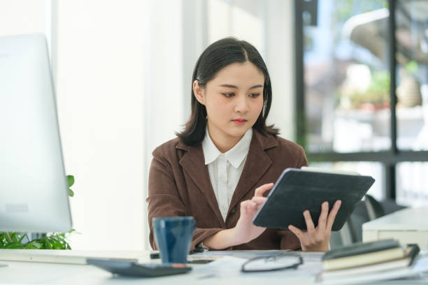 istock Charming young startup businesswoman using digital tablet, planning a project in office 1549473124