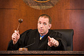 Upset judge swinging gavel and pointing