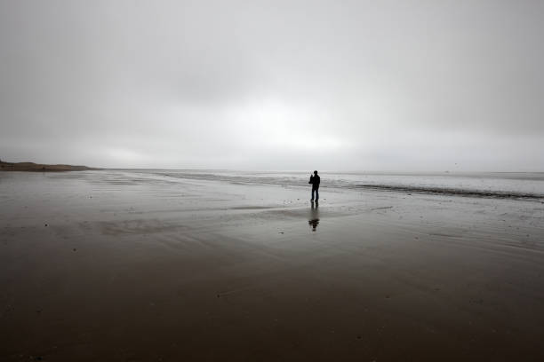 istock Man in silhouette on deserted beach 154947349